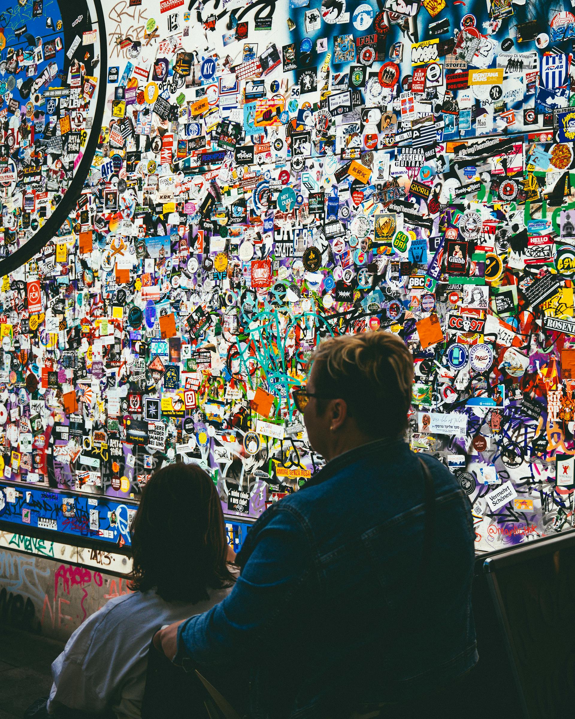 couple passing a wall full of logos